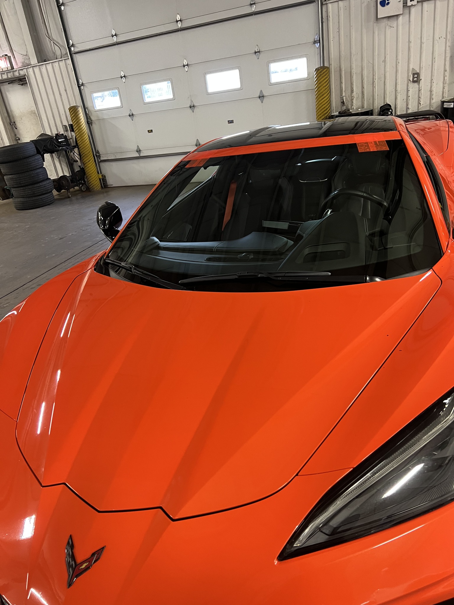Completed windshield replacement on an orange Corvette C8 in the B-Rite shop